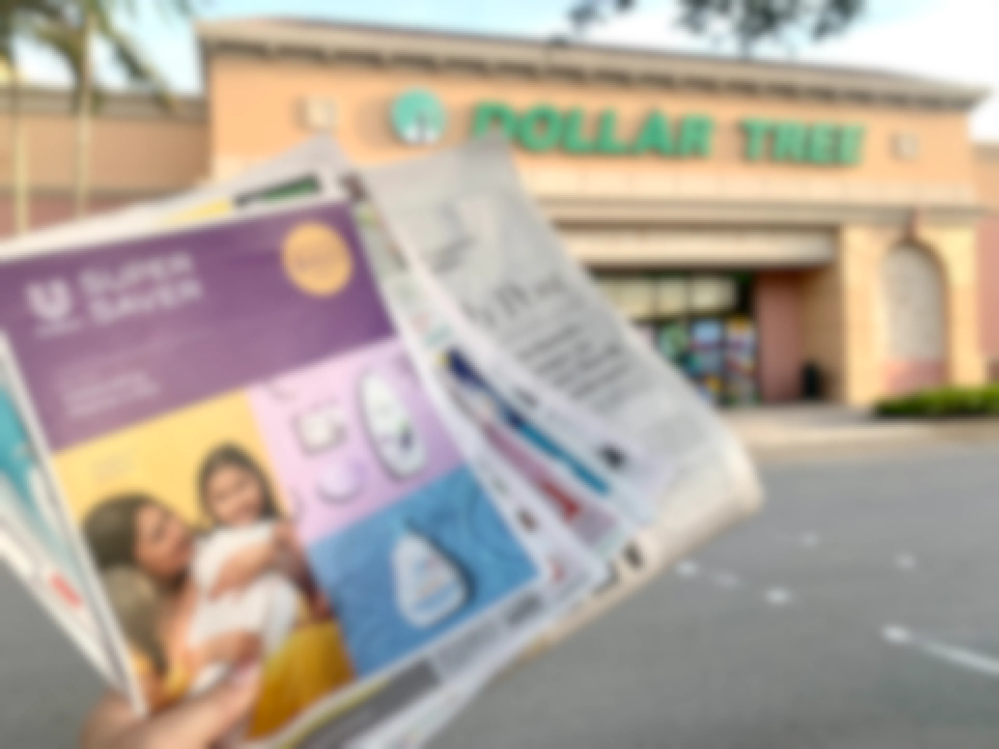 sunday newspaper being held up in front of dollar tree strore