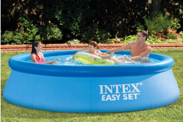 Family sitting in an Intex Easy Set pool outside.