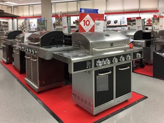 Row of grills. The first one is facing the camera and the rest are to the side. There is a sign above the first grill that has 10% written on it and a price tag that says $549.99