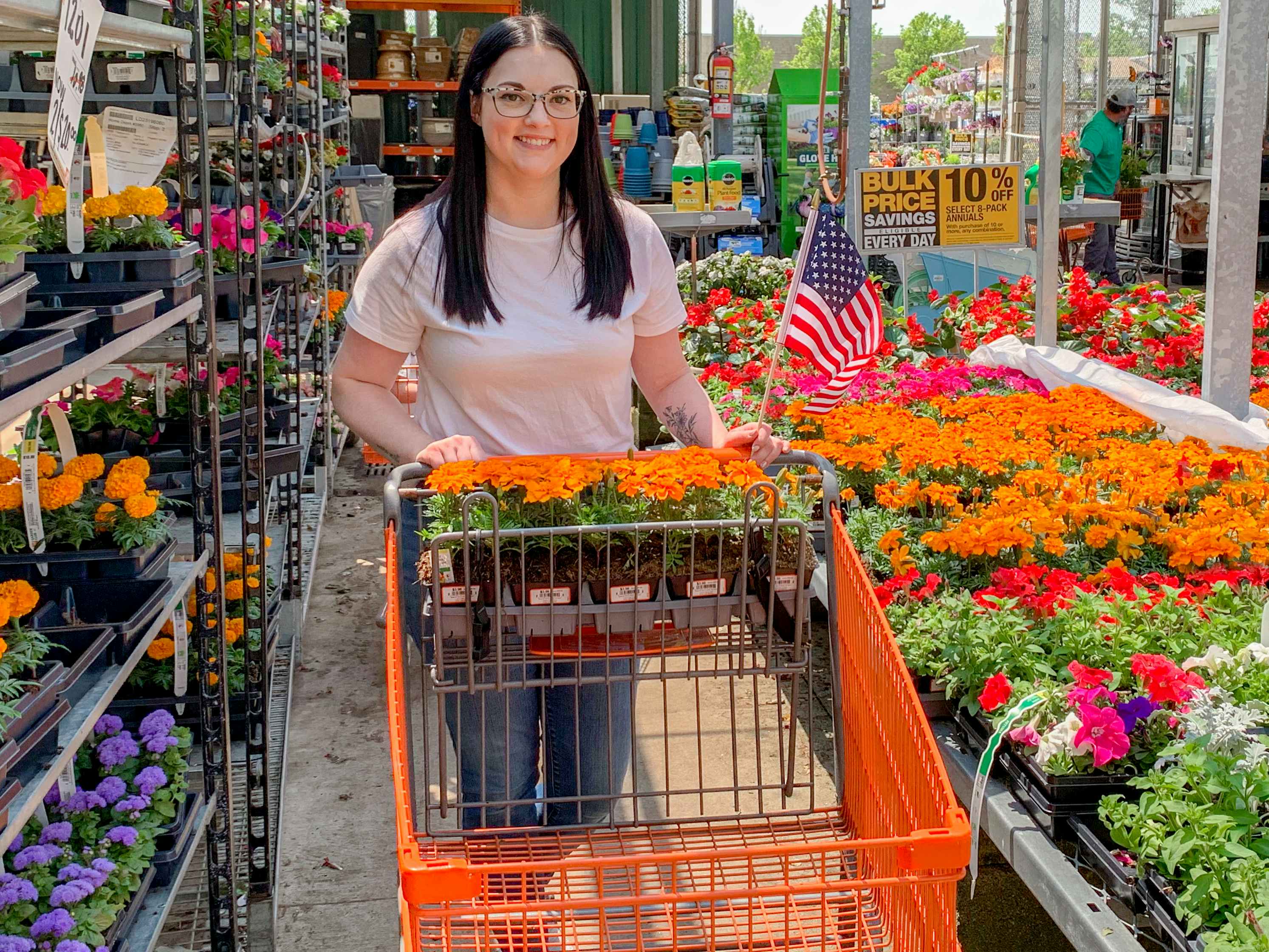 a person holding a flag while pushing a cart at home depot