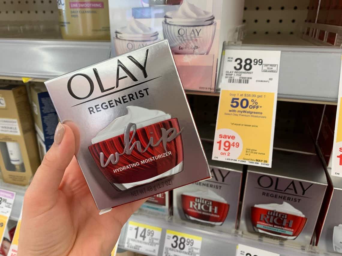 hand holding olay in front of sale sign