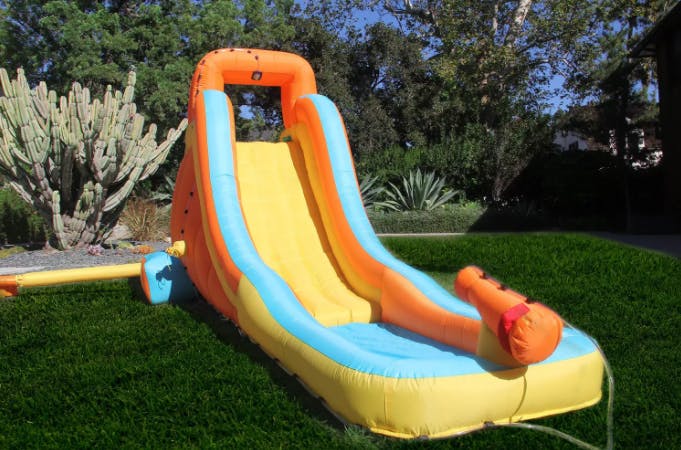 Single slide inflatable water slide set up in a backyard.