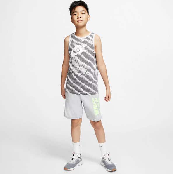 boy wearing nike tank top grey shorts and tennis shoes
