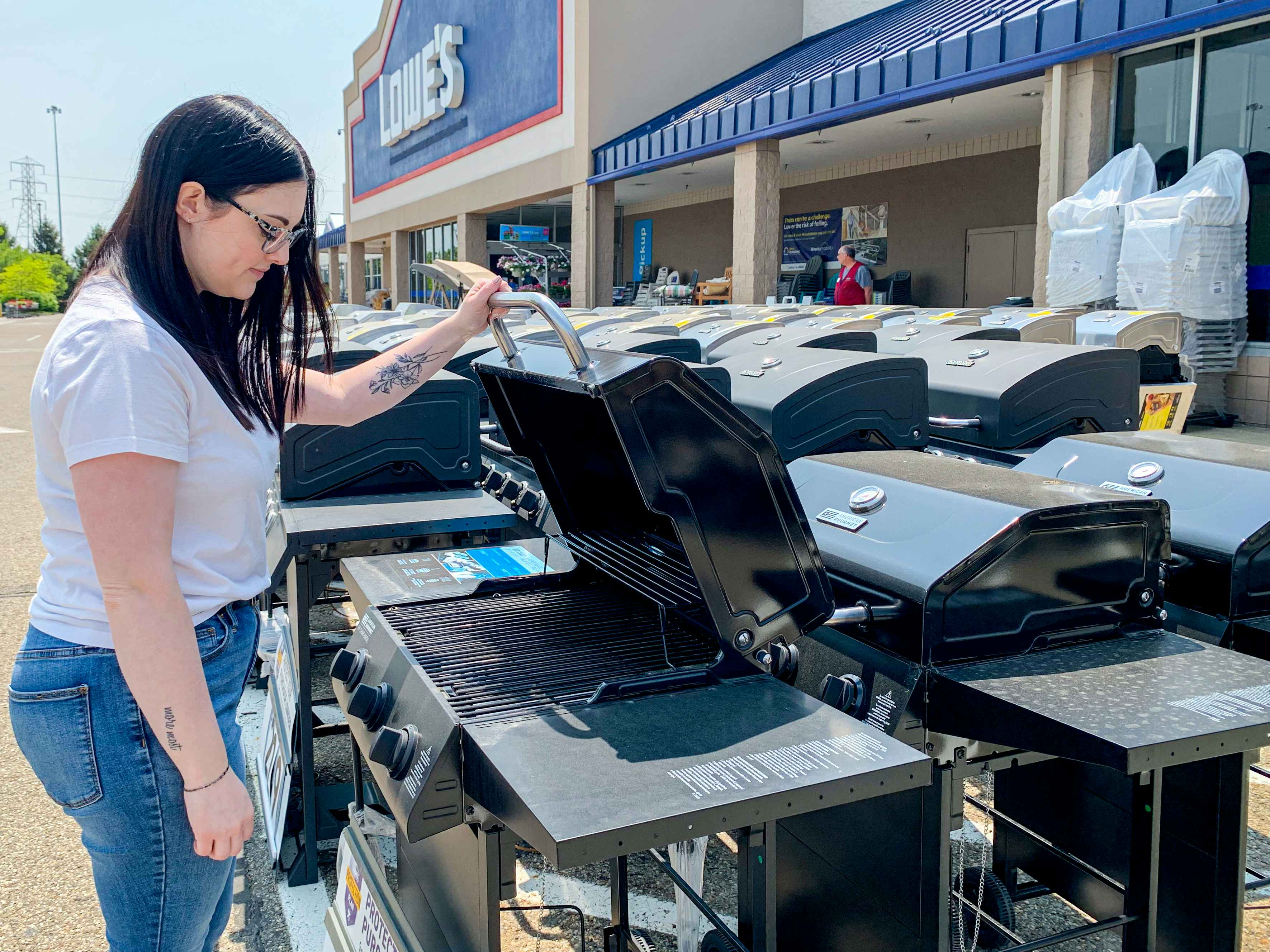 a person looking at grills at lowe's