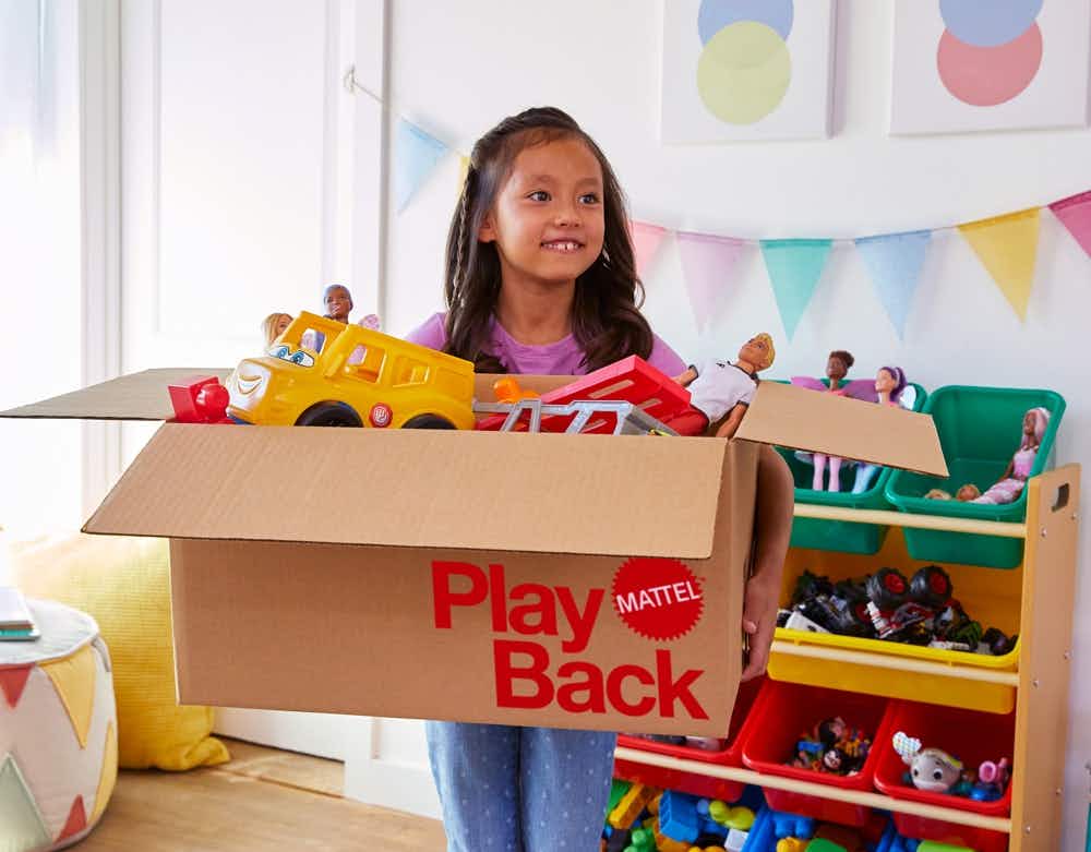A little girl holding a Mattel Play Back box