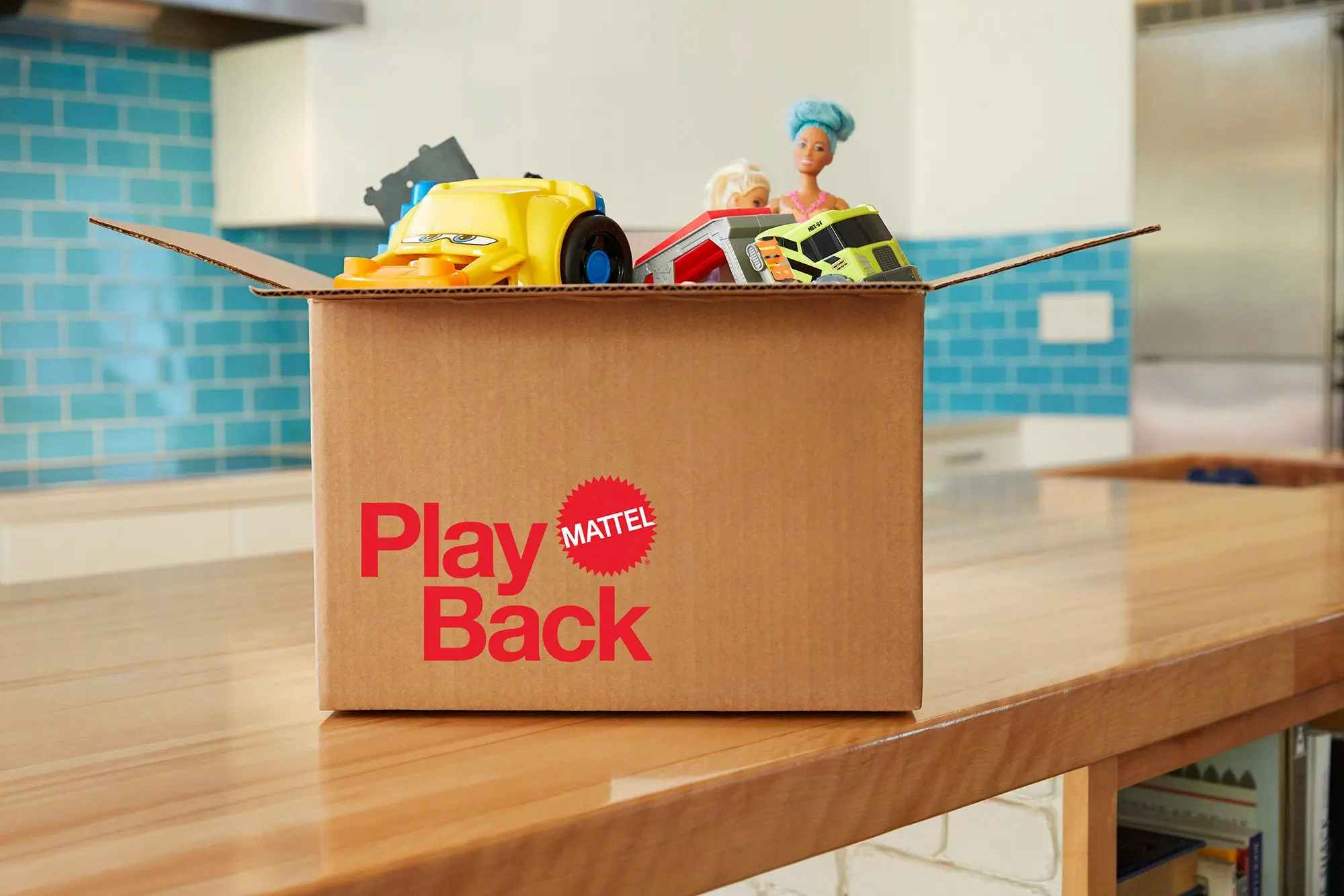 A box of old toys collected for the Mattel PlayBack program sitting on a counter