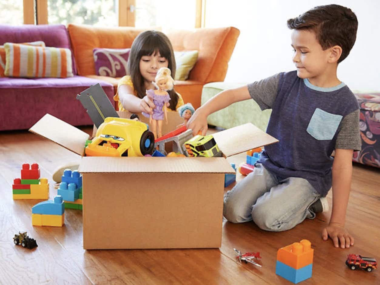 Children putting old toys into a box for the Mattel PlayBack program