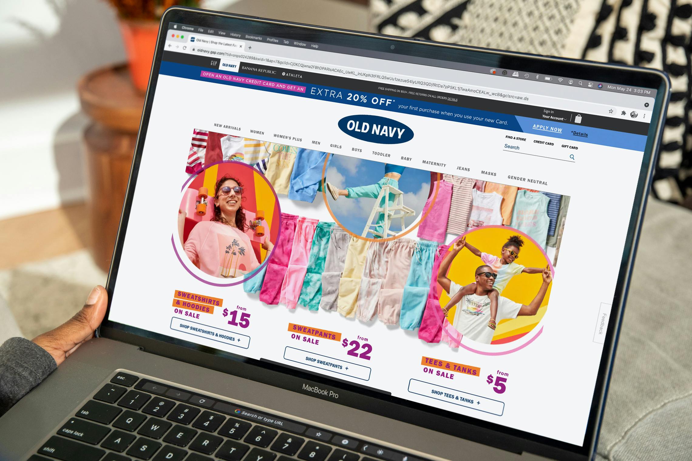 The Old Navy website homepage displayed on an open laptop sitting on a table.