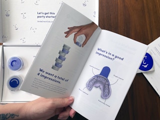 a hand holding a user guide for dental impression trays