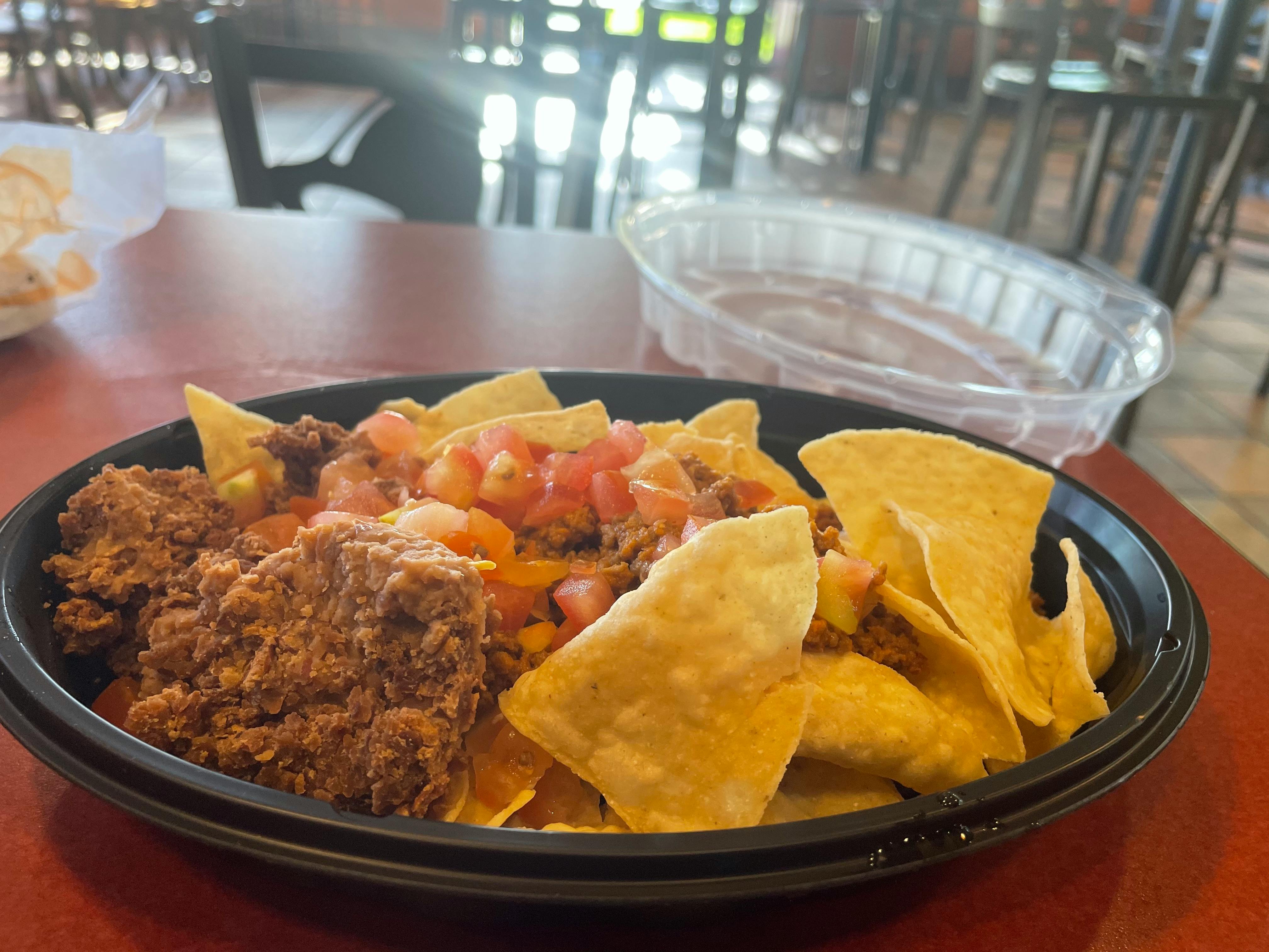 A bowl of "fresco style" vegan nachos from Taco Bell sitting on a table.