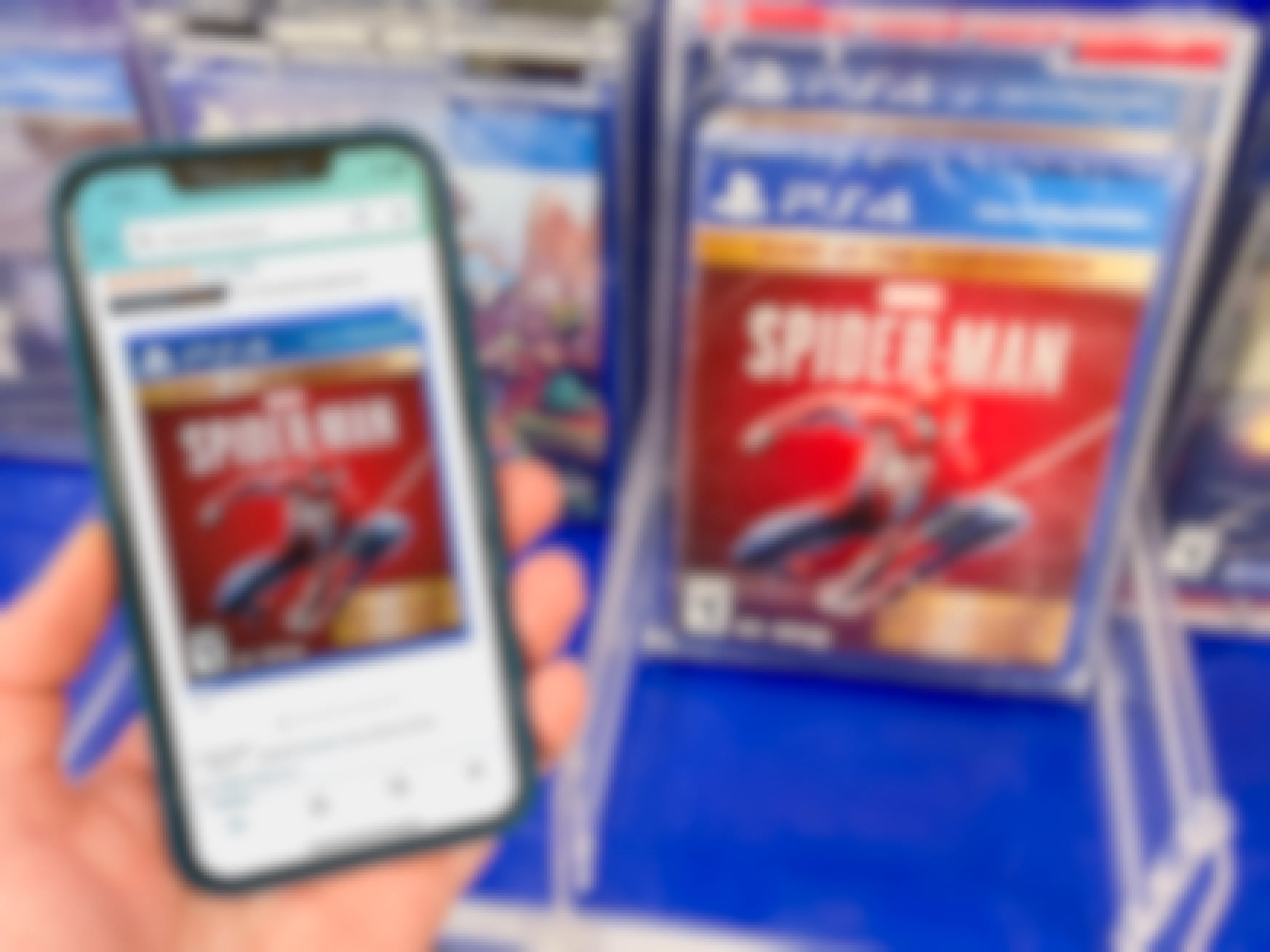 A Sony Spiderman game on a shelf at Target. A cell phone displaying the price on the game from Amazon held next to it.