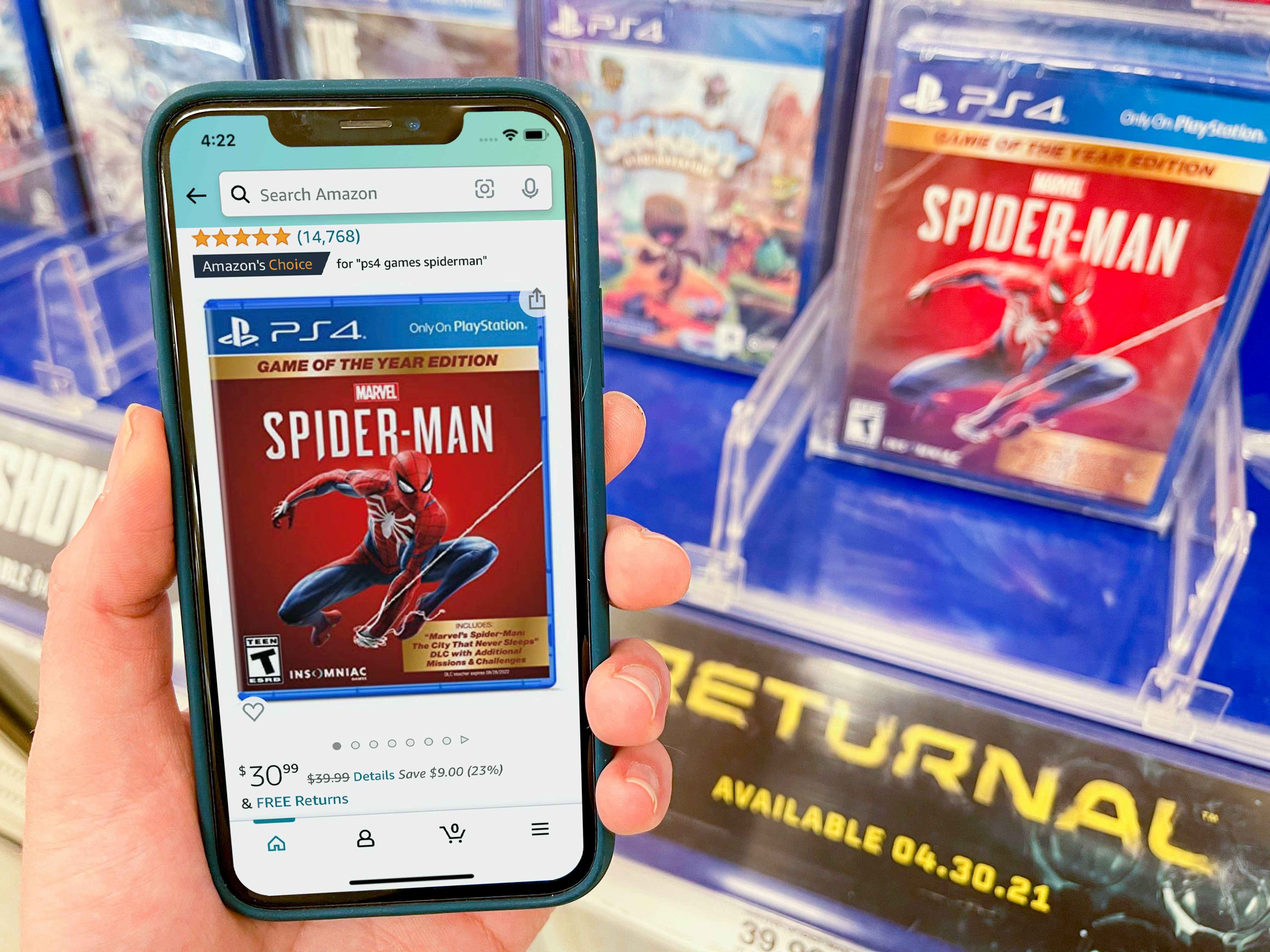 A Sony Spiderman game on a shelf at Target. A cell phone displaying the price on the game from Amazon held next to it.