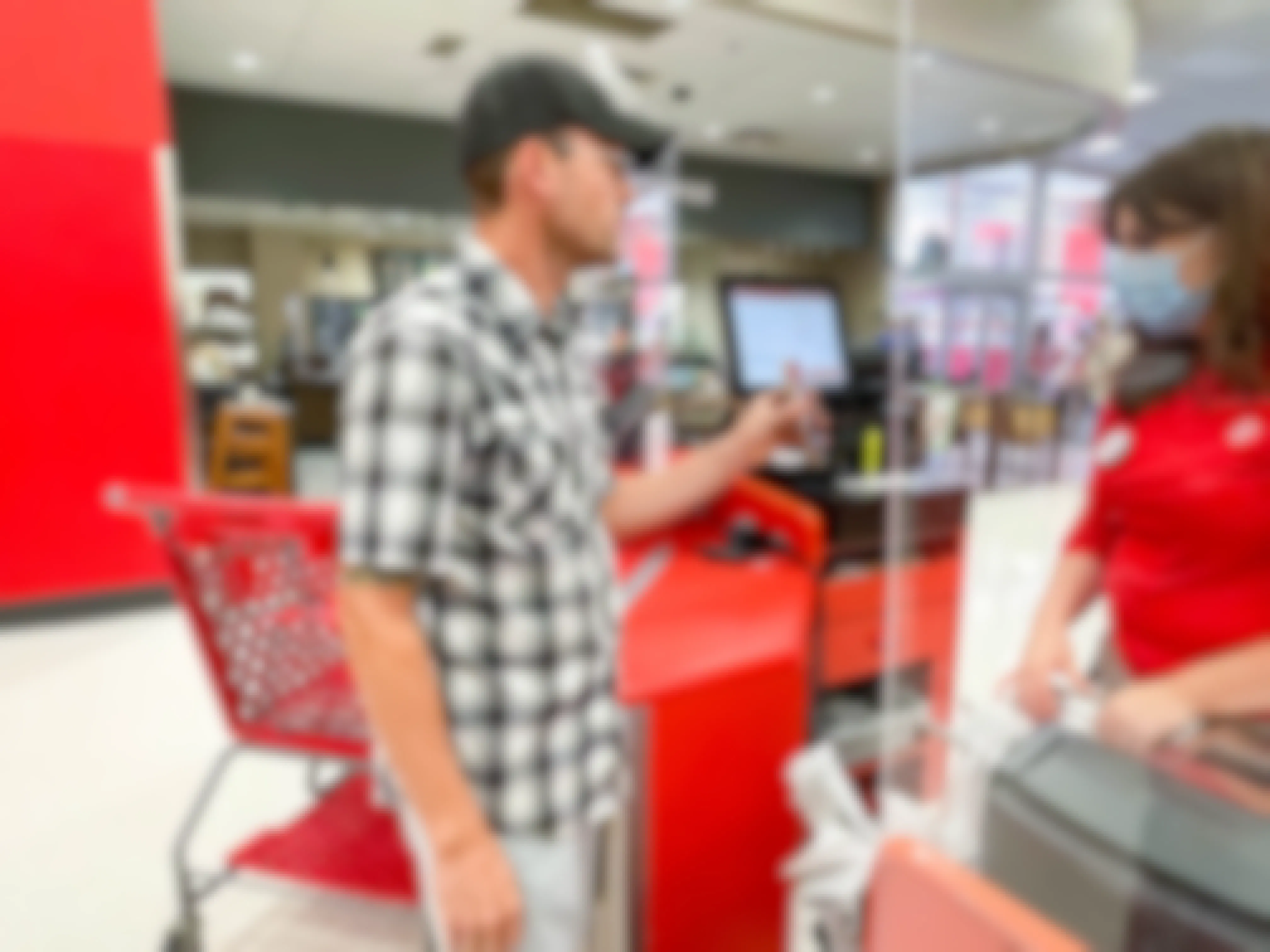Man showing a cellphone to Target employee at a checkout stand.