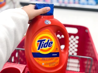 hand holding lid o detergent bottle in shopping cart