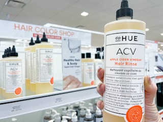 Woman holding hair product in front of display