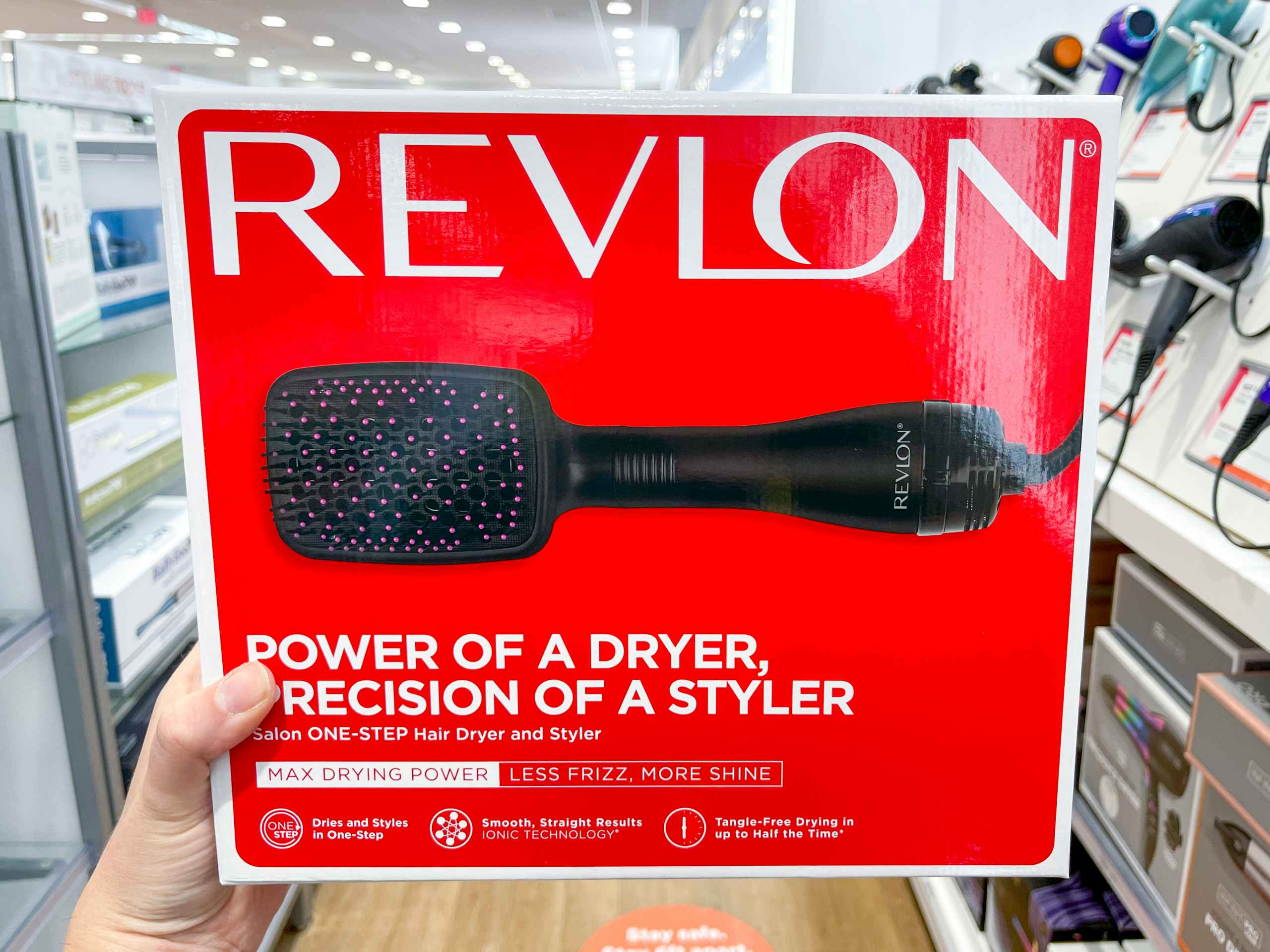 Woman holding box of Revlon one-step hair dryer.