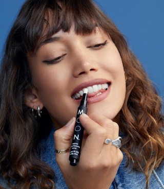Woman using a teeth whitening pen.