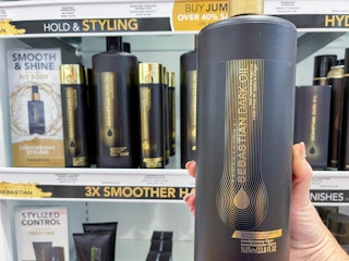 Woman holding hair product in front of display