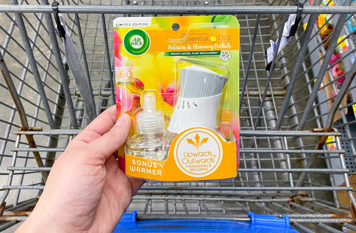 air wick scented oil starter kit held by hand in front of walmart cart
