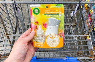 air wick scented oil starter kit held by hand in front of walmart cart