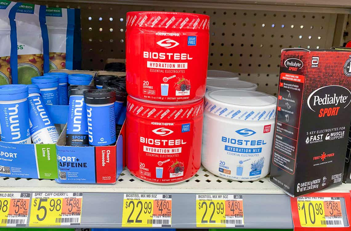 two bright red cans of biosteel hudration mix stacked one on top of the other on walmart shelf showing price tag