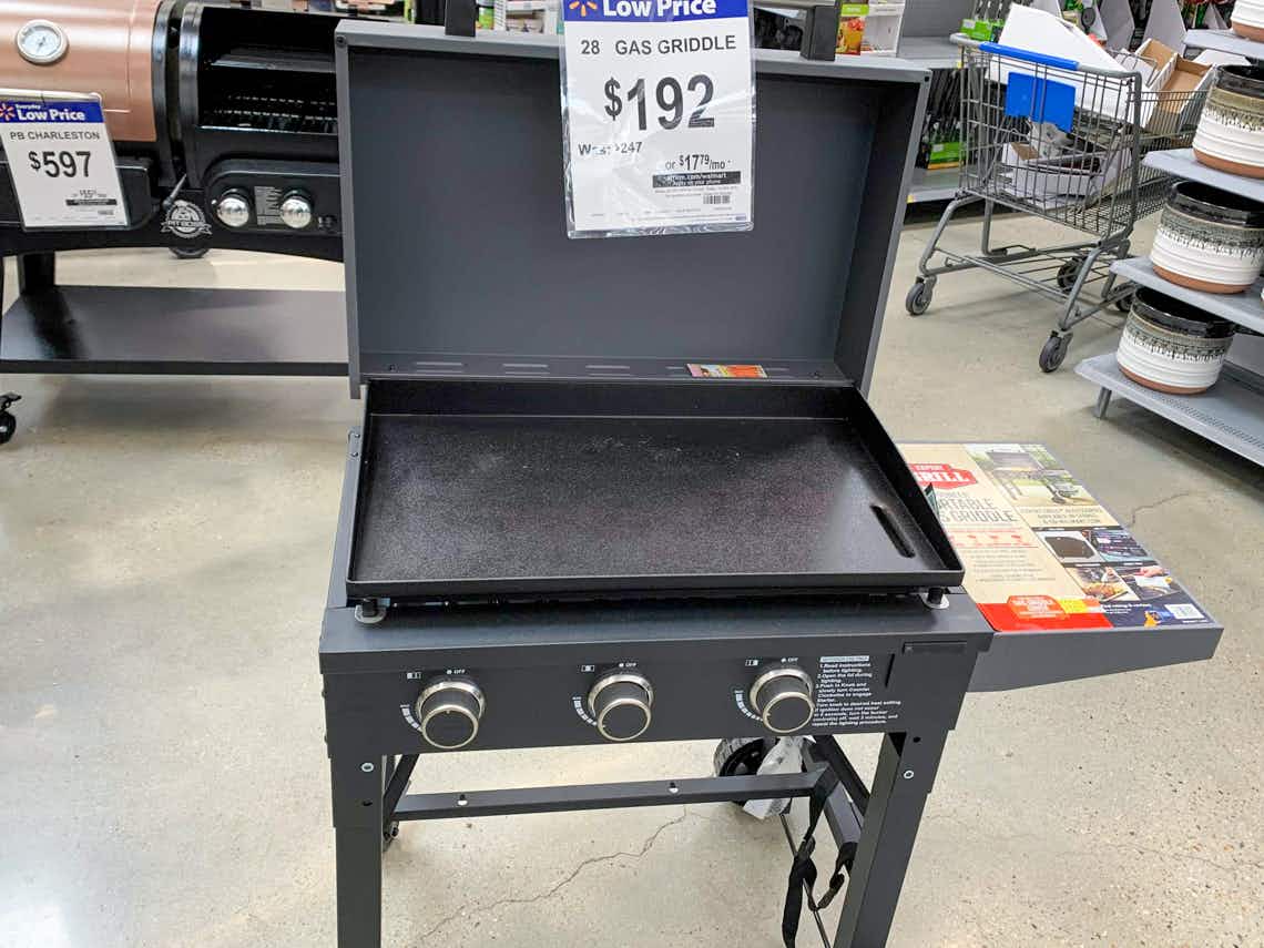 the expert grill pioneer portable propane gas griddle open with a white price sign that has $192 on it at a walmart store