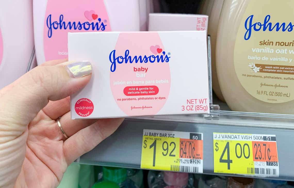 single pack of johnson's baby bar in a pink box being held by a left hand in front of the walmart shelf showing the price tag