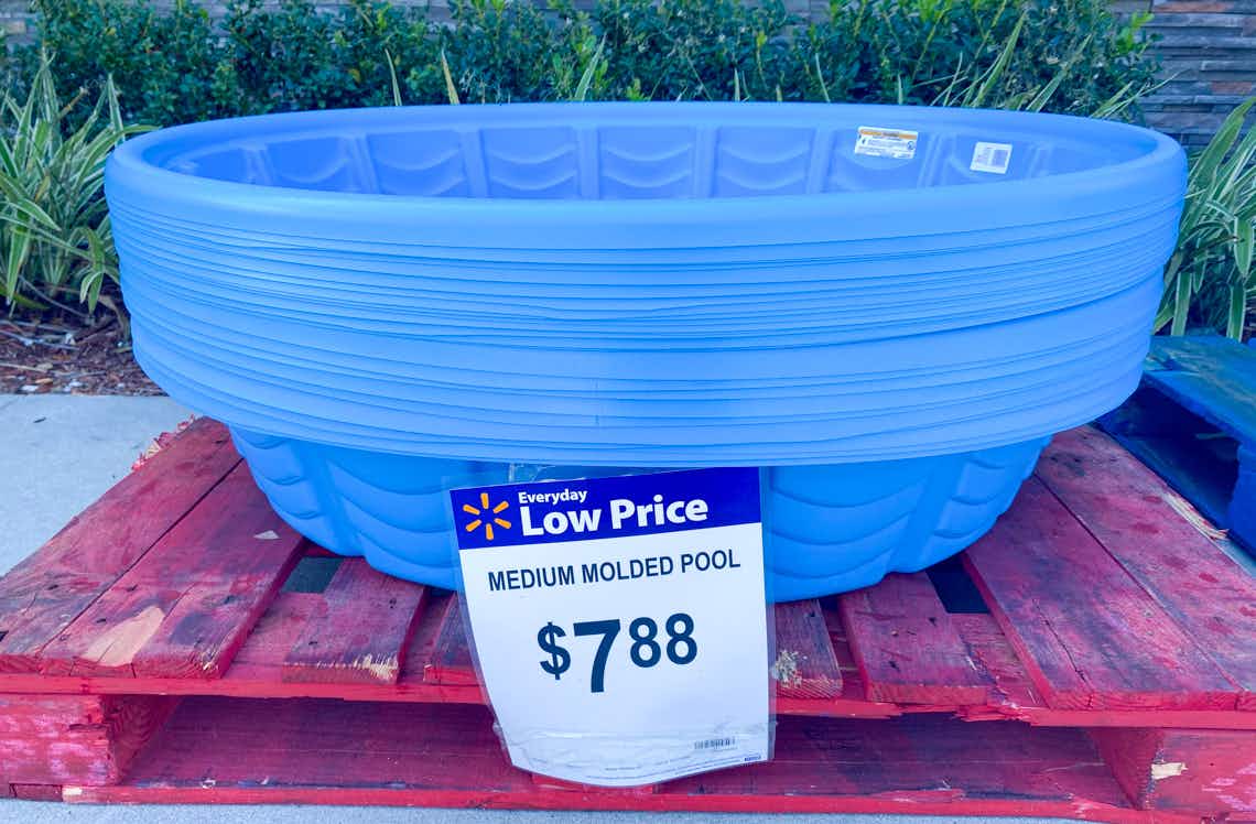 A stack of plastic kiddie pools sitting on a pallet at Walmart, marked as $7.88