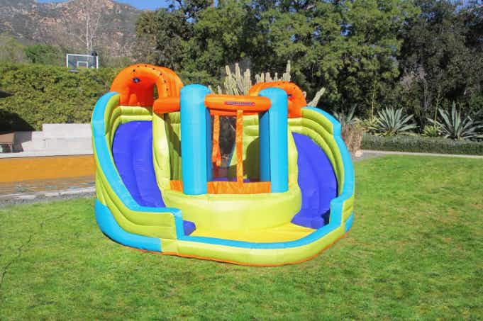 A water slide bounce house set up on a grassy lawn.