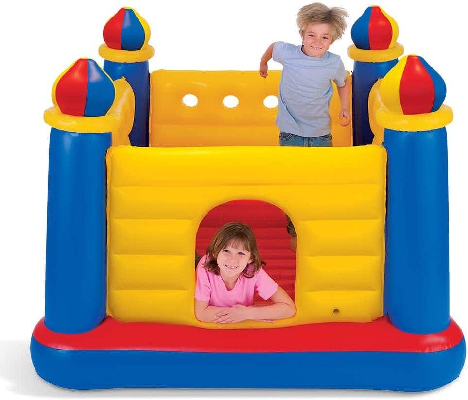 Two children playing in an Intex castle-themed bounce house