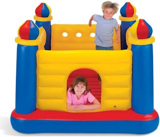 Two children playing in an Intex castle-themed bounce house