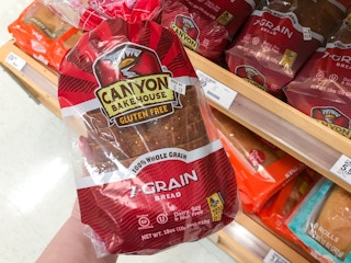 hand holding a bag of canyon bakehouse gluten free bread at target