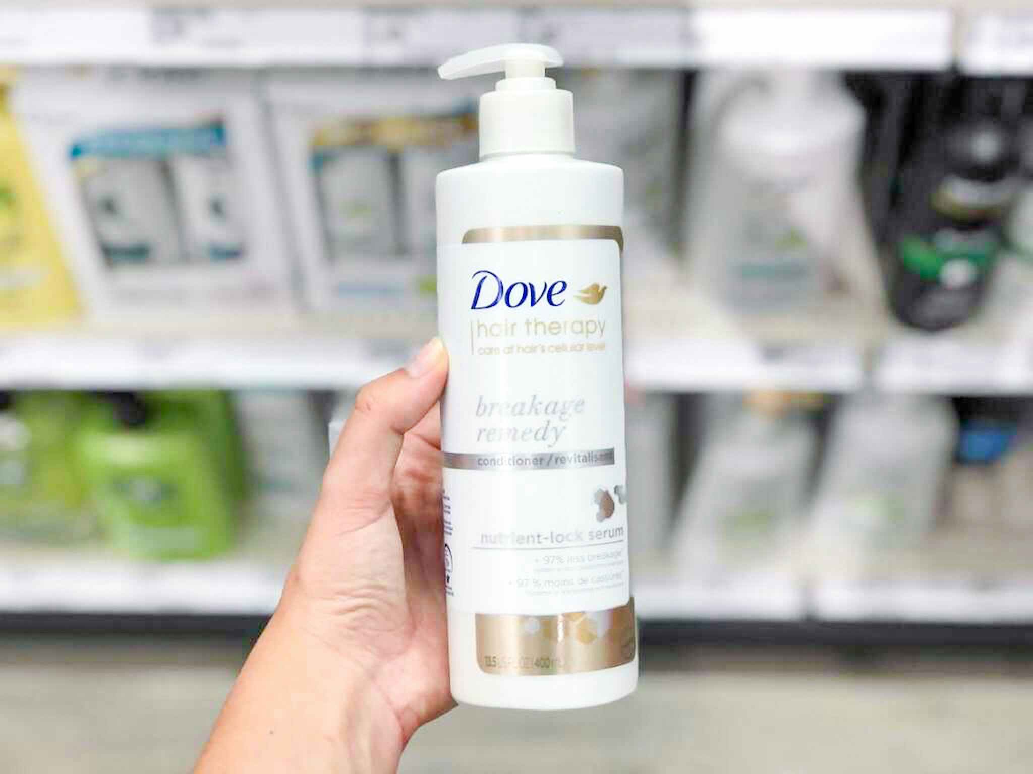 hand holding a bottle of dove hair therapy at target