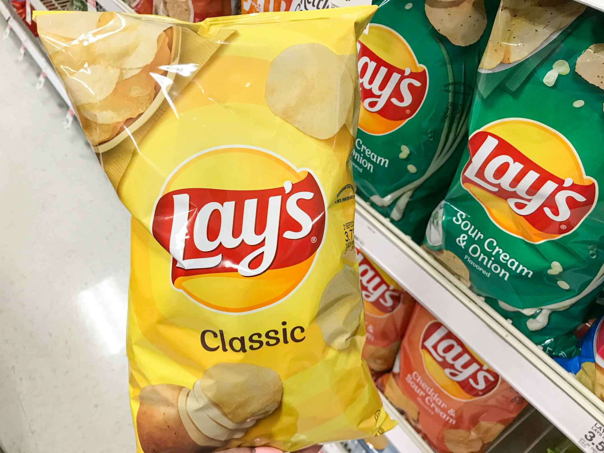 hand holding a bag of lay's potato chips at target