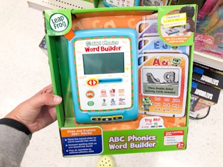 hand holding Leap Frog toy on clearance at Target in front of toy shelf