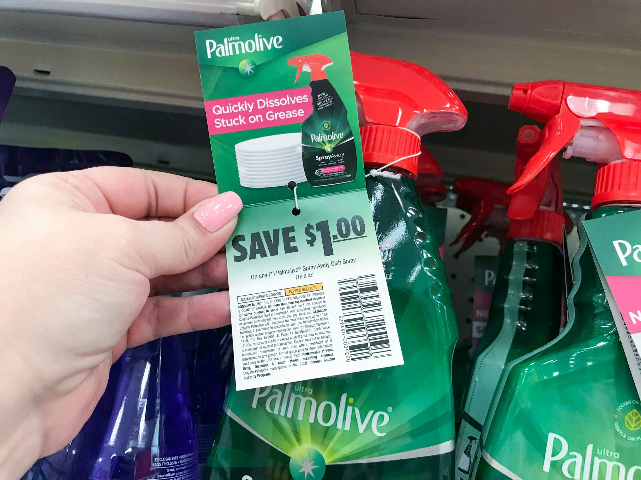 hand holding a palmolive dish spray coupon at target