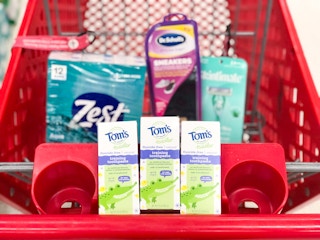 box of bar soap, shoe inserts, three boxes of toothpaste and a pack of razors in a shopping cart