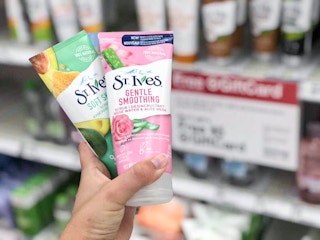 hand holding two bottles of st. ives face scrub at Target