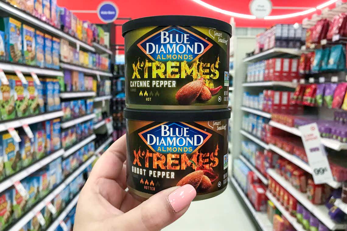 two cans of blue diamond xtremes almonds stacked one on top of the other held in center of target aisle