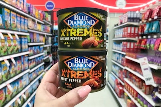 two cans of blue diamond xtremes almonds stacked one on top of the other held in center of target aisle