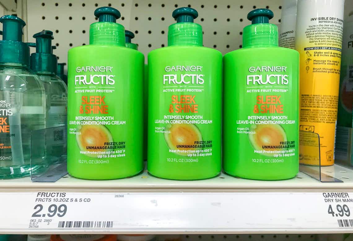 three bottles of garnier fructis sleek and smooth leave-in conditioner lined up on a target shelf