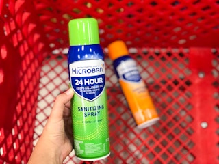 hand holding bottle of Microban in front og shoppping cart with another bottle of Microban