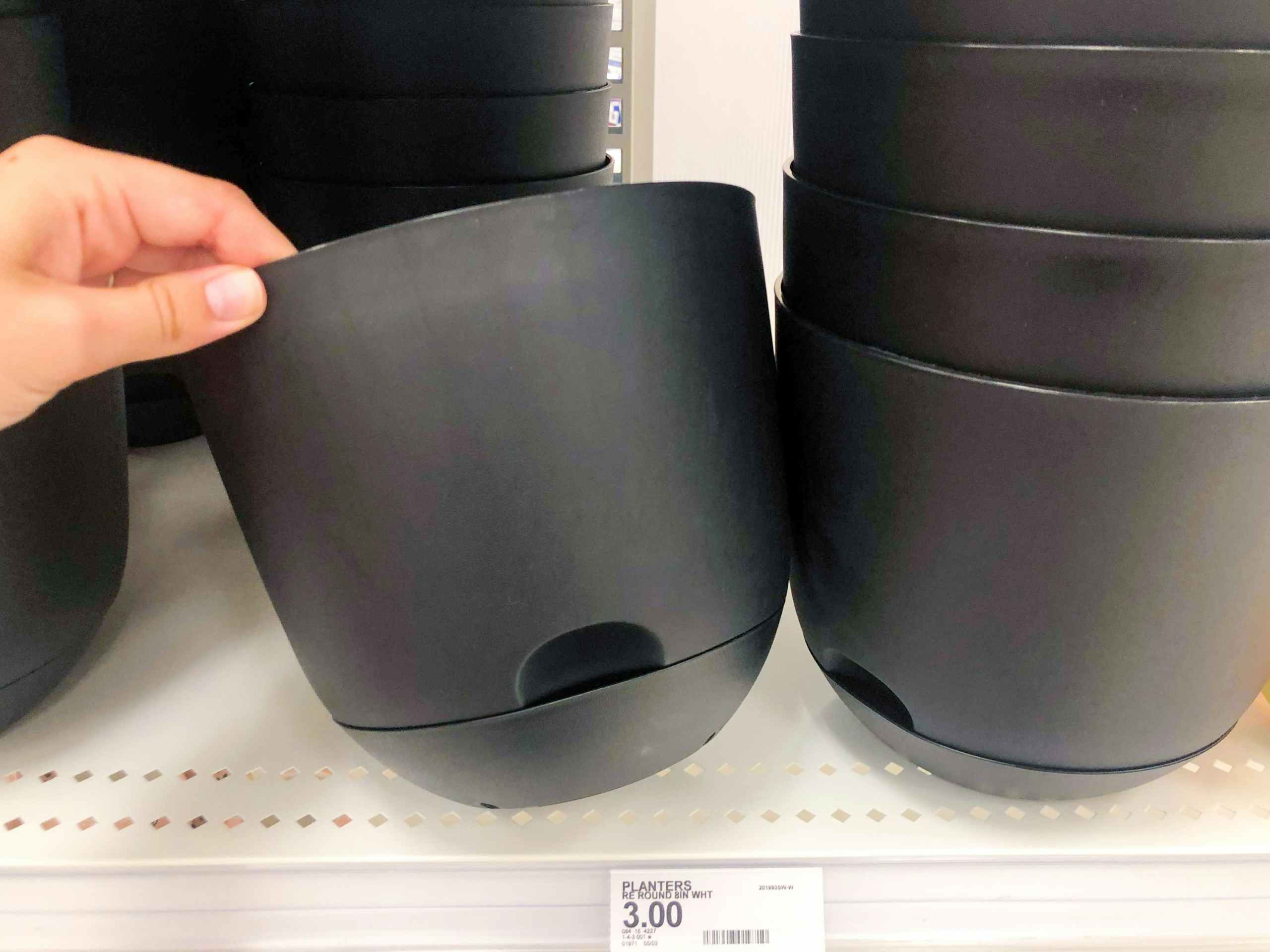 hand holding plastic planter on store shelf