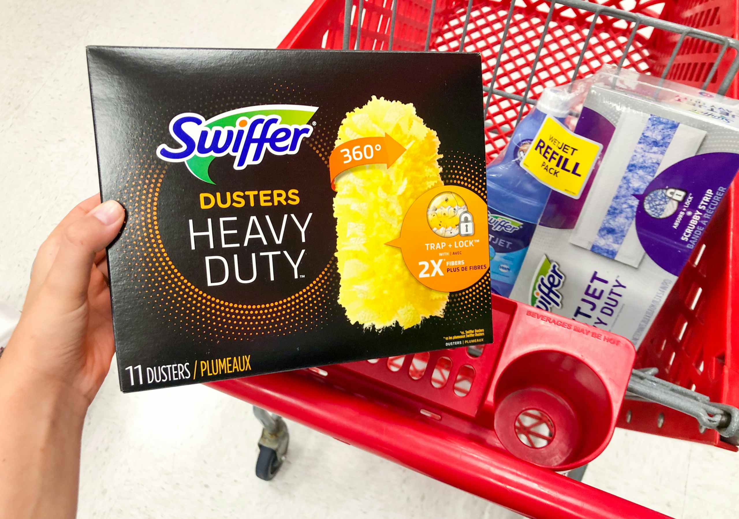 hand holding box of swiffer dusters in front of shopping cart