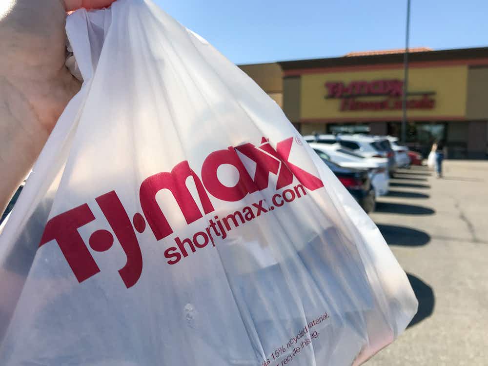 a person holding up a tj maxx shopping bag