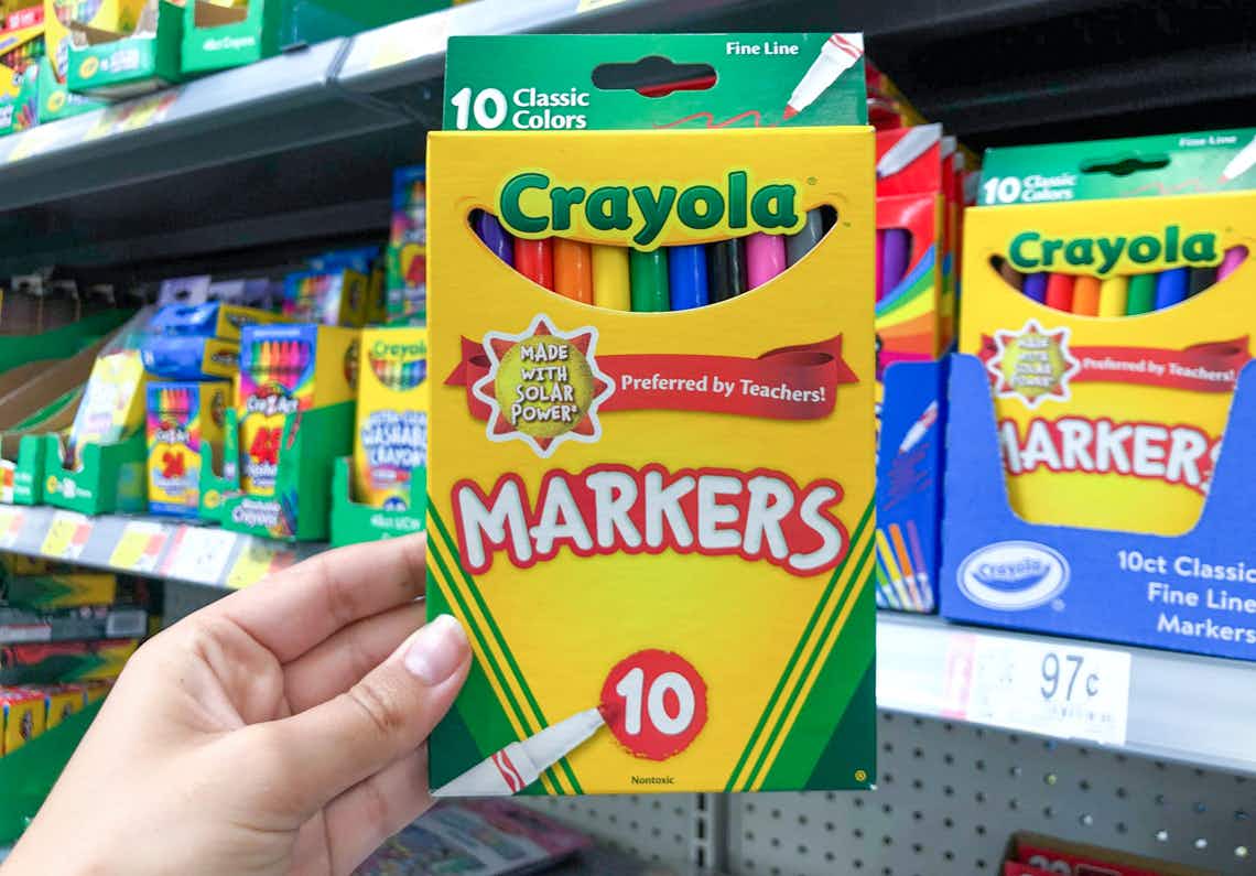 box of crayola classic colors thin markers held in front of markers on shelves