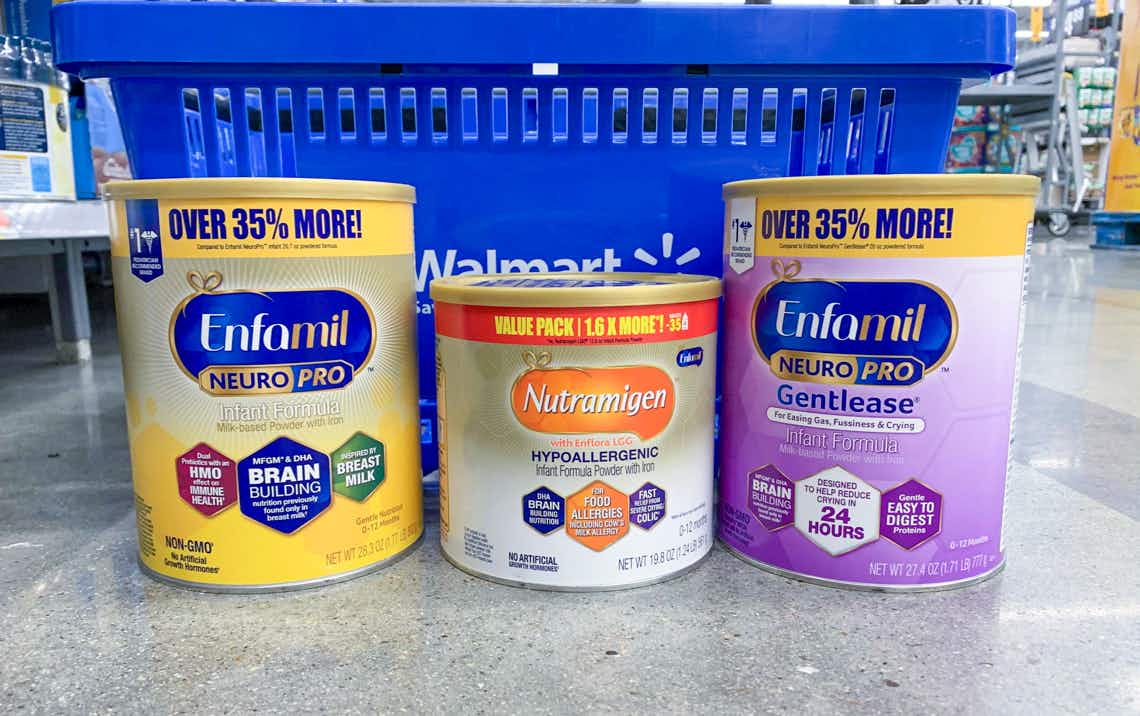 three cans of enfamil infant formula in front of a blue walmart hand basket sitting on floor 