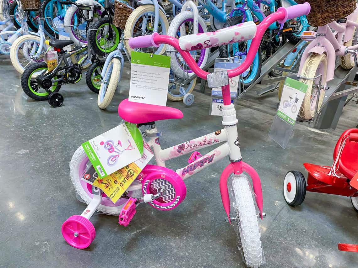 huffy girls 12 inch sea star bike with hot pink training wheels with other kids bikes in background
