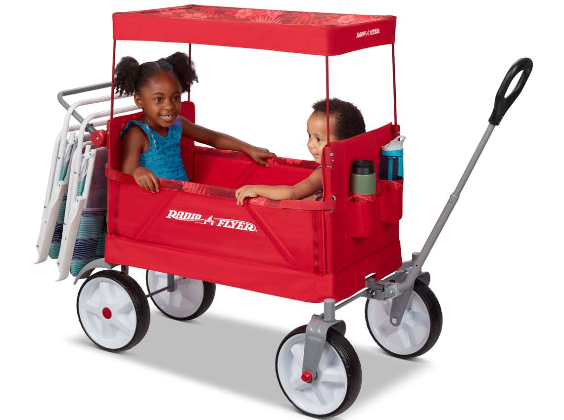 stock photo of radio flyer beach wagon with kids in sitting under canopy on white background