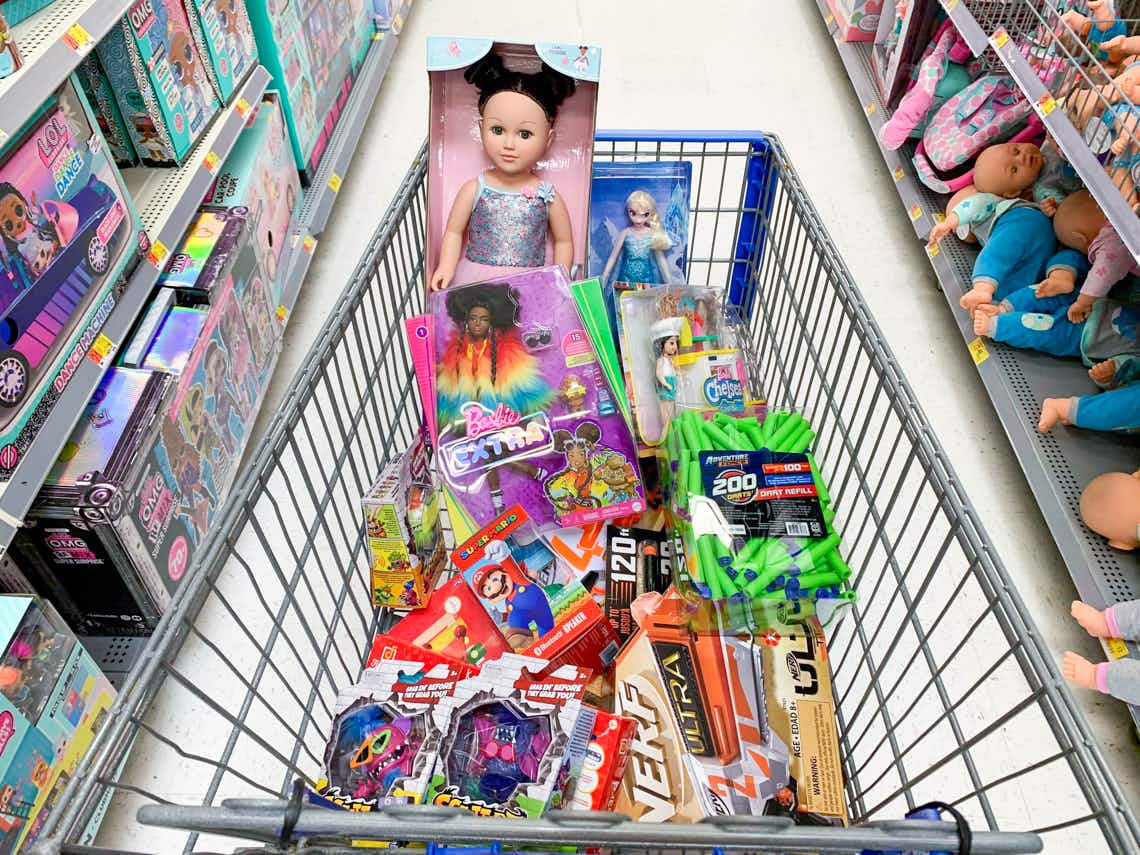 Walmart cart full of clearance toys parked in a toy aisle.